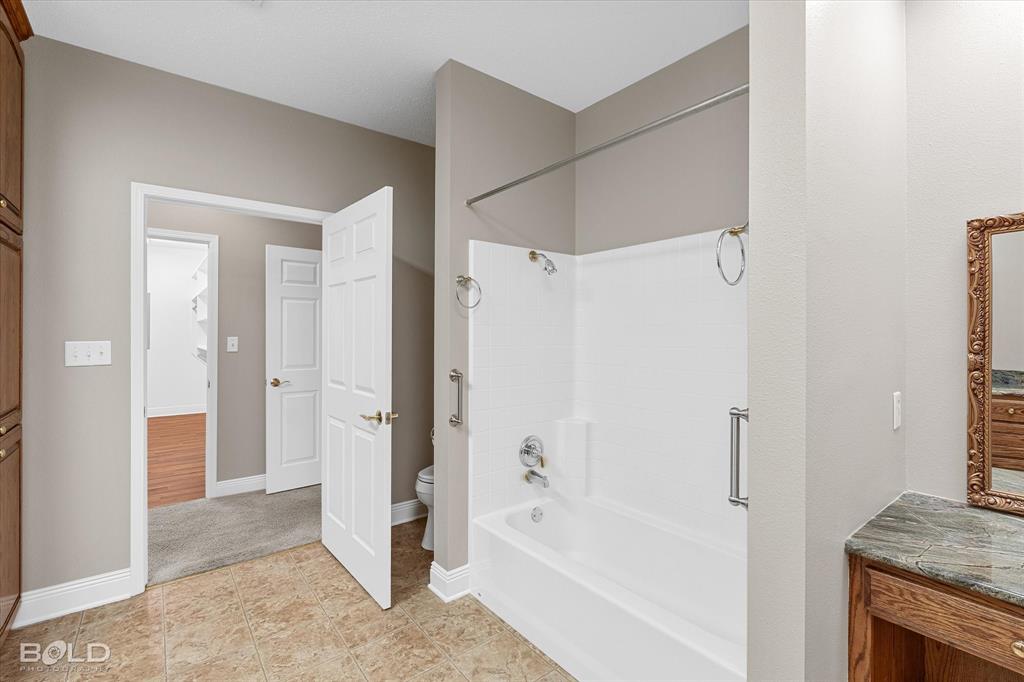 429 Robinson Lane Homer, LA 71040 - Photo 31 of 40 a bathroom with a granite countertop shower a mirror and a sink