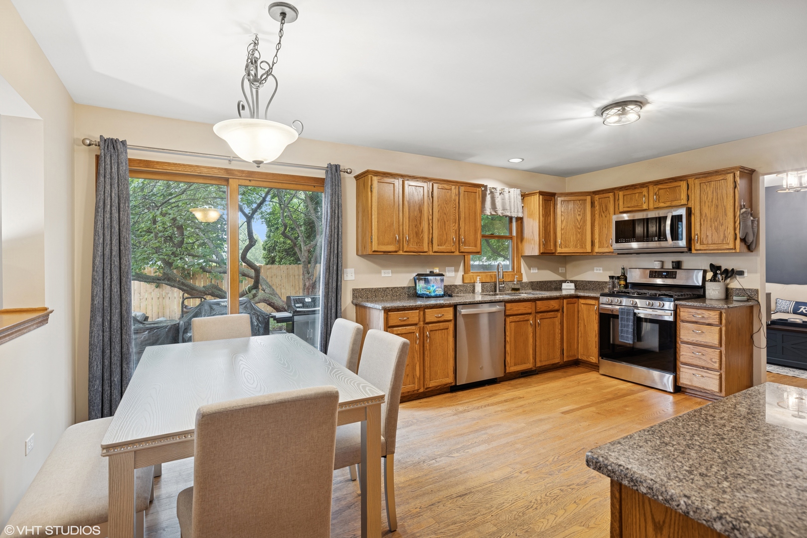 1177 Dovercliff Way Crystal Lake, IL 60014 - Photo 9 of 32 a kitchen with a stove a sink a kitchen island a stove and a refrigerator with wooden floor