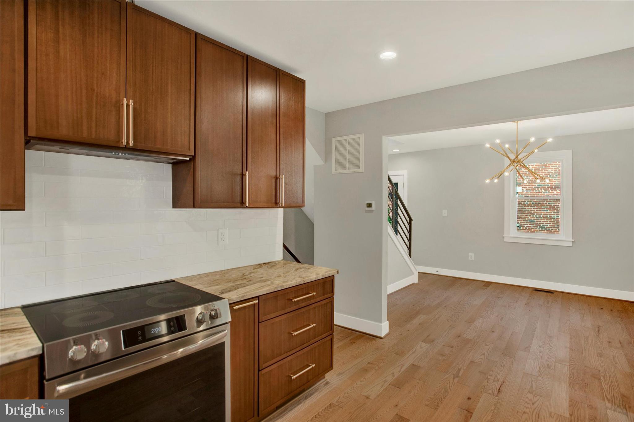 2054 34th Street Southeast Washington, DC 20020 - Photo 11 of 43 a kitchen with a stove and a wooden floor