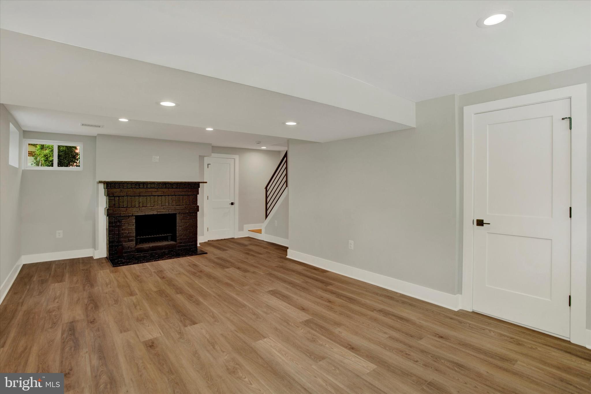 2054 34th Street Southeast Washington, DC 20020 - Photo 17 of 43 a view of an empty room with wooden floor fireplace and a window