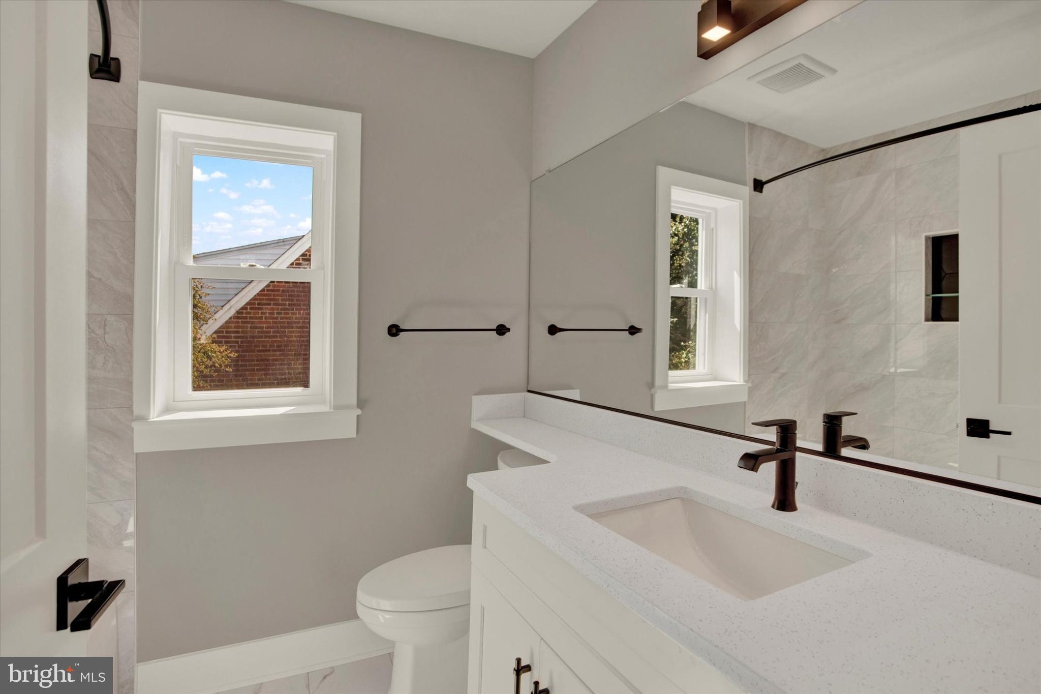 2054 34th Street Southeast Washington, DC 20020 - Photo 27 of 43 a bathroom with a sink a toilet and a mirror