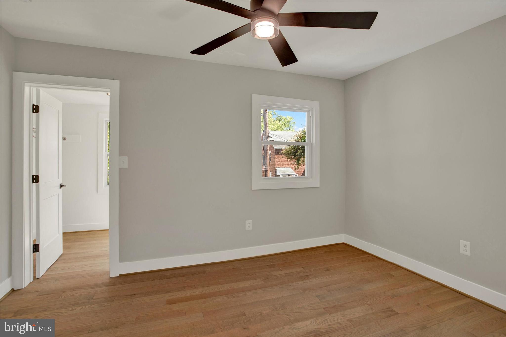 2054 34th Street Southeast Washington, DC 20020 - Photo 28 of 43 an empty room with wooden floor ceiling fan and windows