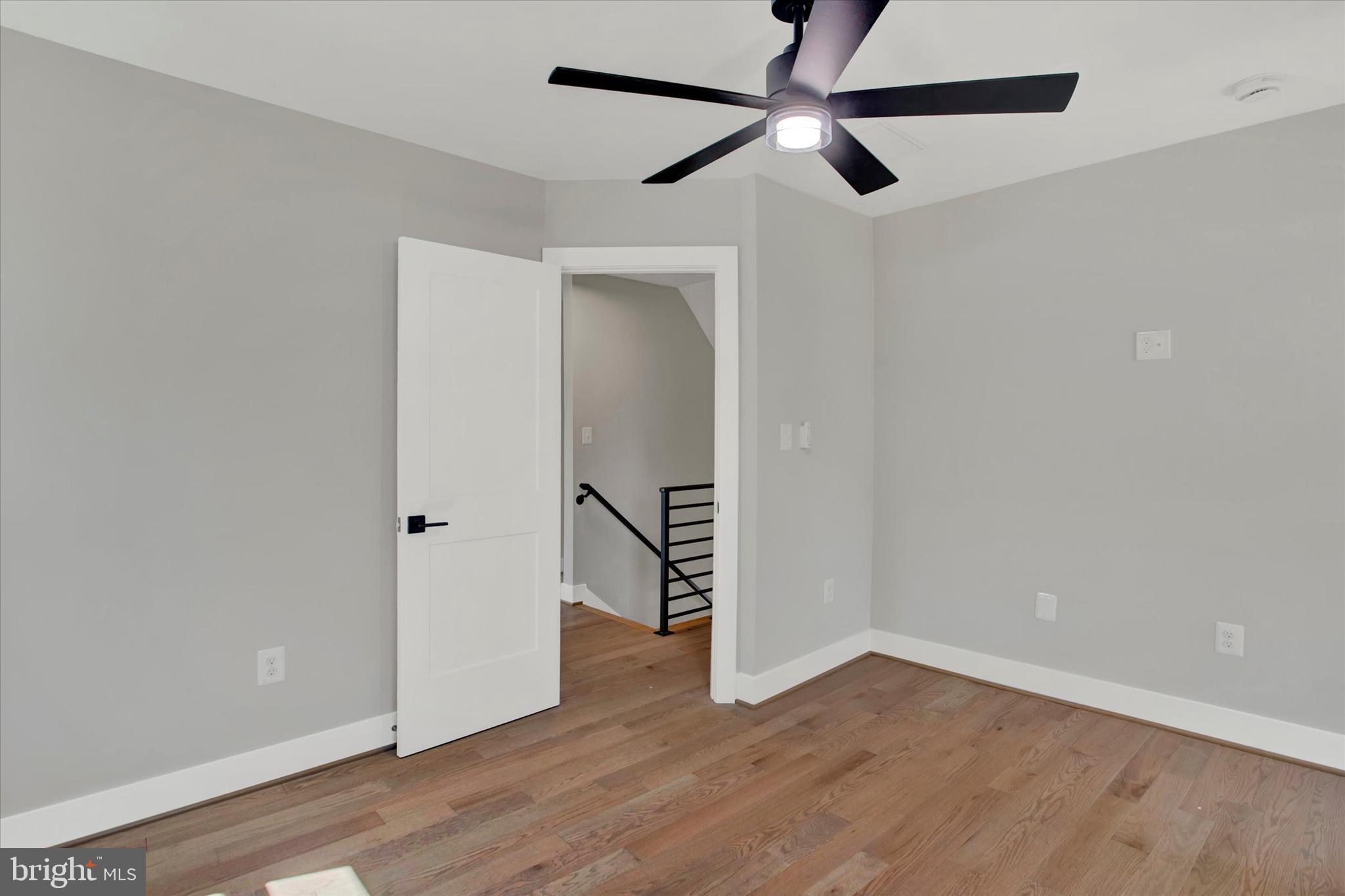 2054 34th Street Southeast Washington, DC 20020 - Photo 30 of 43 an empty room with wooden floor and a ceiling fan