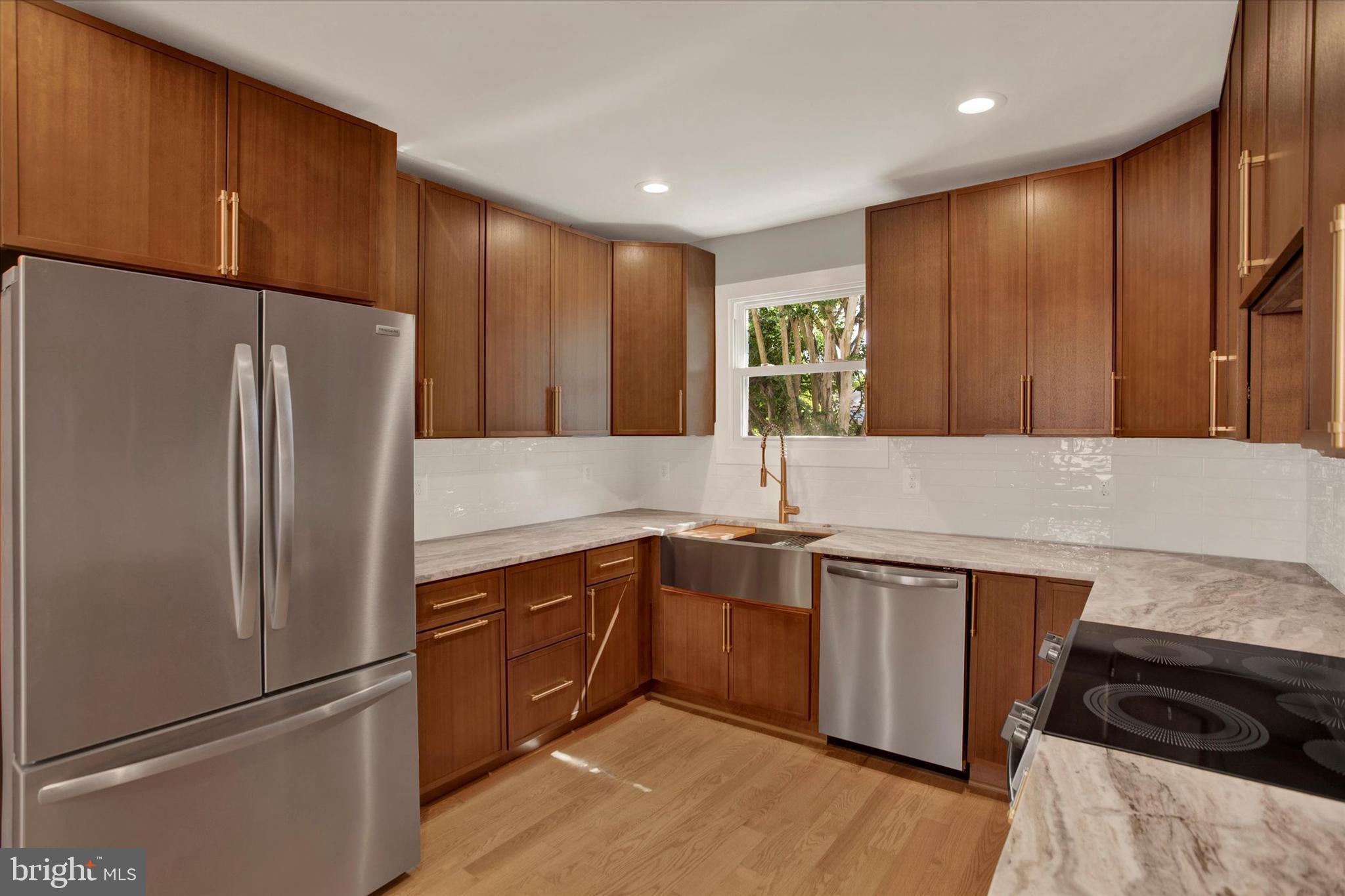 2054 34th Street Southeast Washington, DC 20020 - Photo 9 of 43 a kitchen with stainless steel appliances granite countertop a refrigerator and a sink