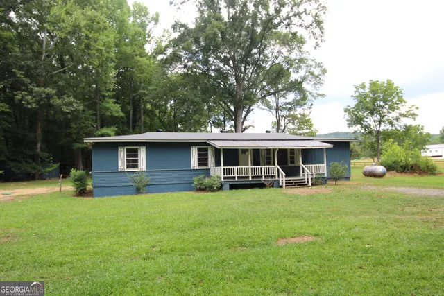 a view of a house with a yard and sitting area