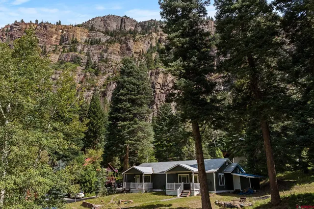 an aerial view of residential house with outdoor space and trees all around