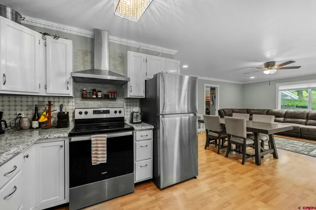 a kitchen with a stove a refrigerator and furniture