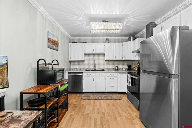 a kitchen with a refrigerator a sink and wooden cabinets