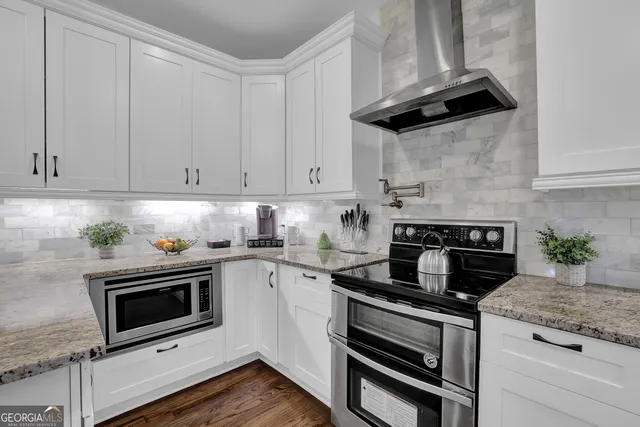 a view of a backyard with lawn chairs under a large tree