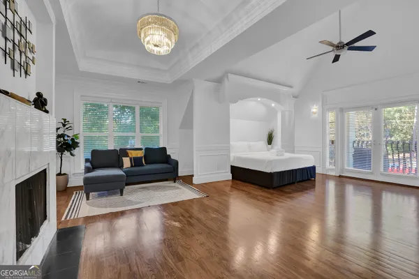 a spacious bedroom with a bed a couch and a large window