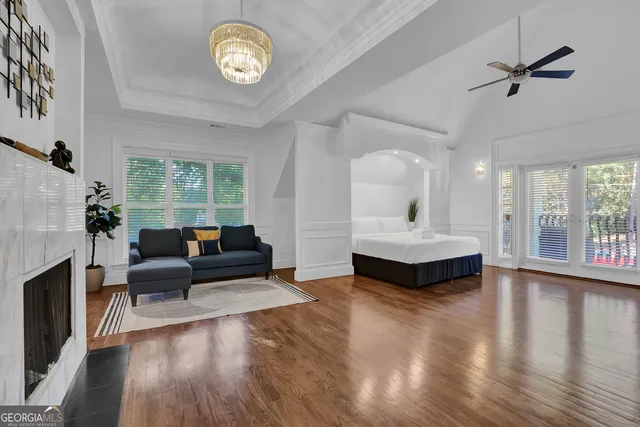 a spacious bedroom with a bed a couch and a large window