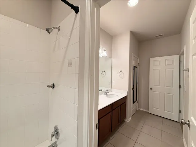 a spacious bathroom with a double vanity sink a mirror and a shower