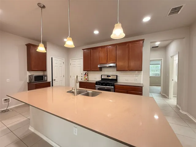 a kitchen with a sink stove and cabinets