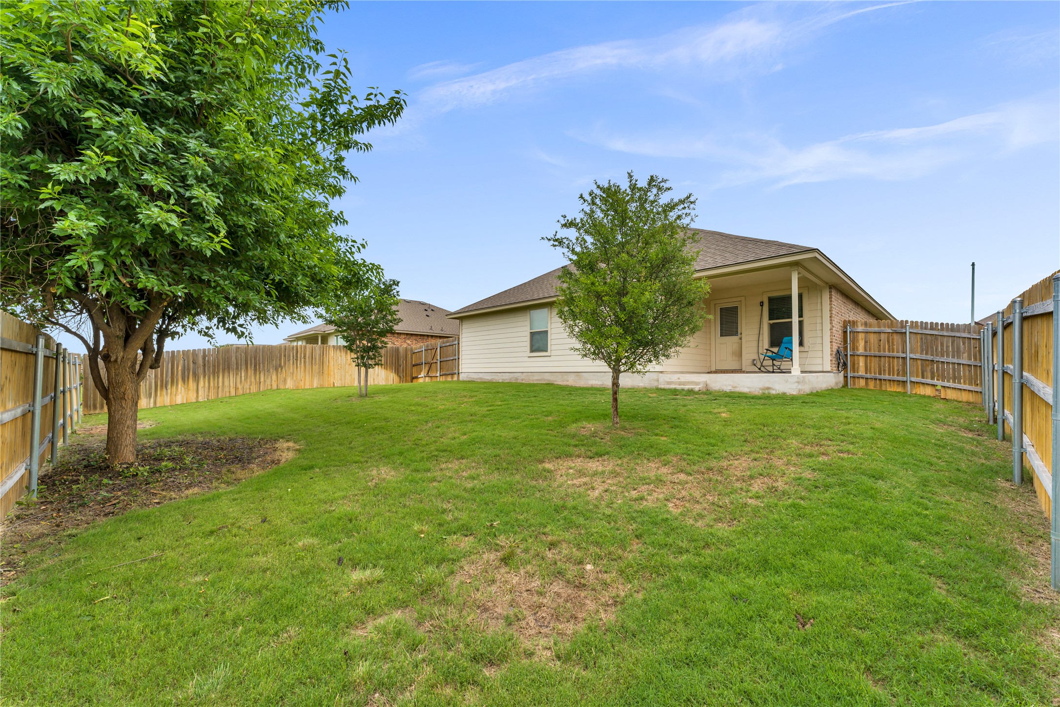 132 Cinnamon Loop Burnet, TX 78611 - Photo 26 of 27 Expansive backyard featuring a manicured lawn, established trees, and a full privacy fence