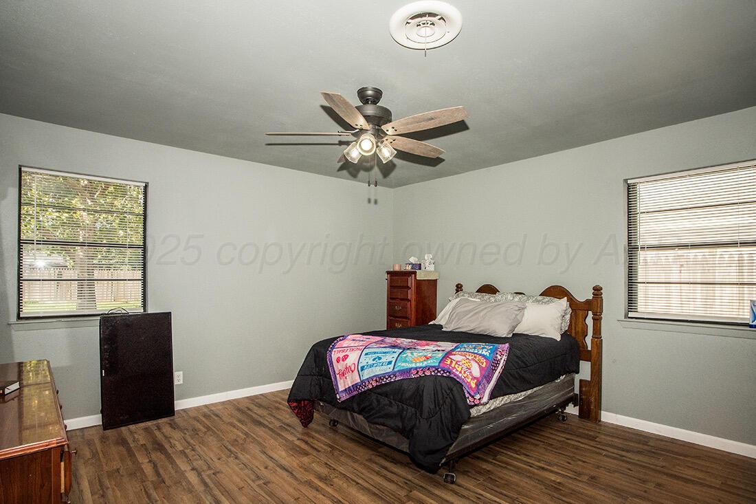 4206 Arden Road Amarillo, TX 79110 - Photo 14 of 24 a bedroom with a bed and wooden floor