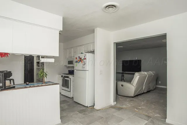 a view of kitchen with furniture and a refrigerator