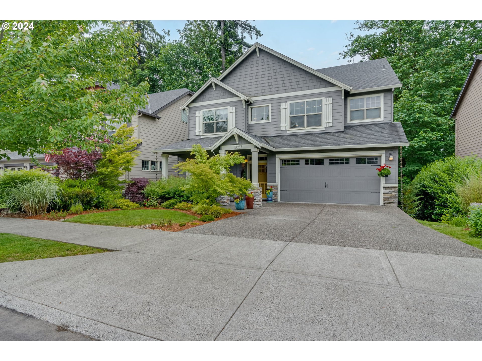 15057 Southeast Glenbrook Road Happy Valley, OR 97015 - Photo 1 of 43 a front view of a house with a garden and plants