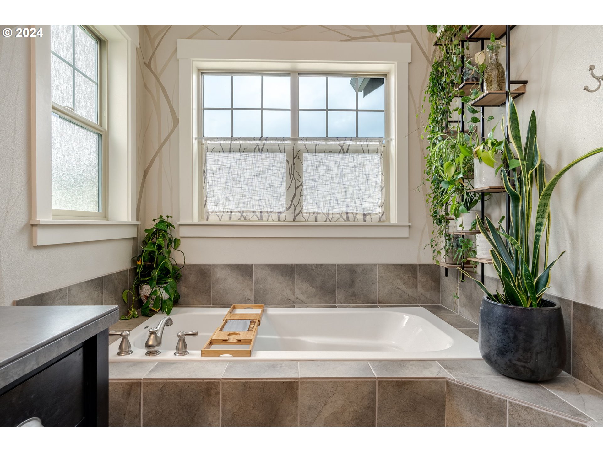 15057 Southeast Glenbrook Road Happy Valley, OR 97015 - Photo 20 of 43 a bathroom with a bathtub a sink a window and a potted plant