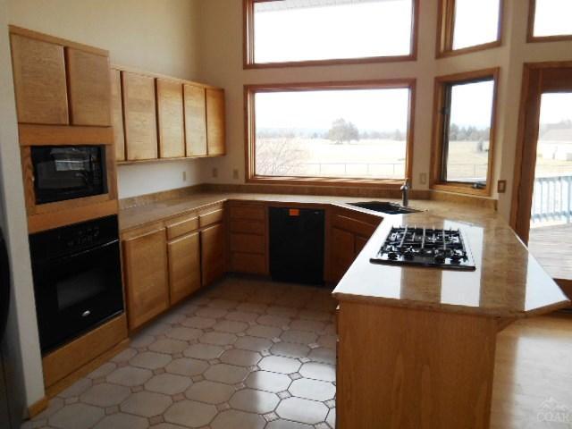 18989 Couch Market Road Bend, OR 97703 - Photo 9 of 25 a kitchen with stainless steel appliances a stove a sink and a microwave