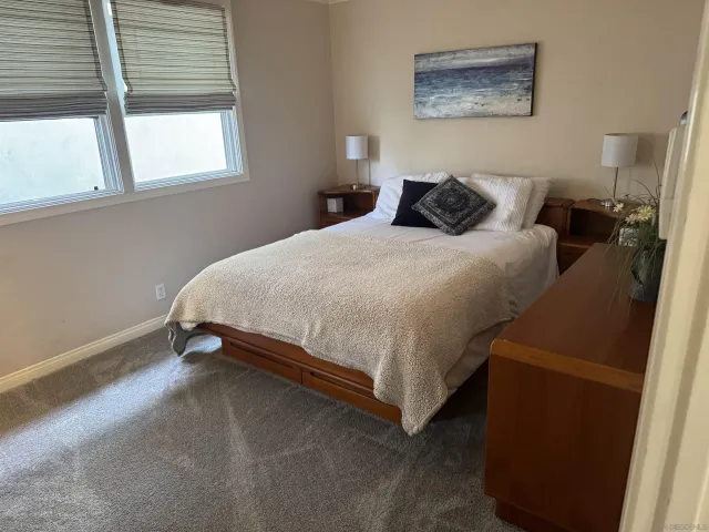 a bedroom with a bed and painting on the wall