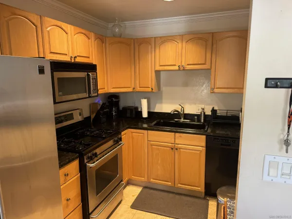 a kitchen with a sink and a stove next to a window