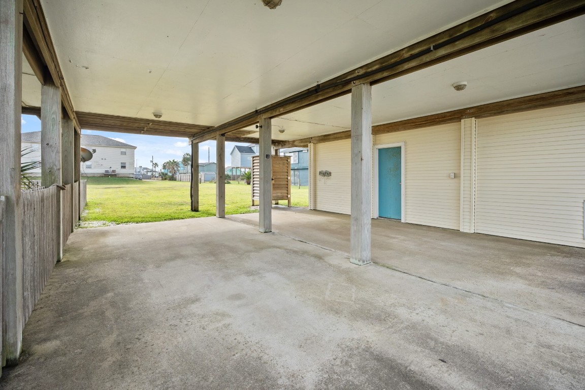 16507 Captain Kidd Road Jamaica Beach, TX 77554 - Photo 15 of 37 Spacious covered patio and carport area with concrete flooring and open sides, providing plenty of play area and parking.