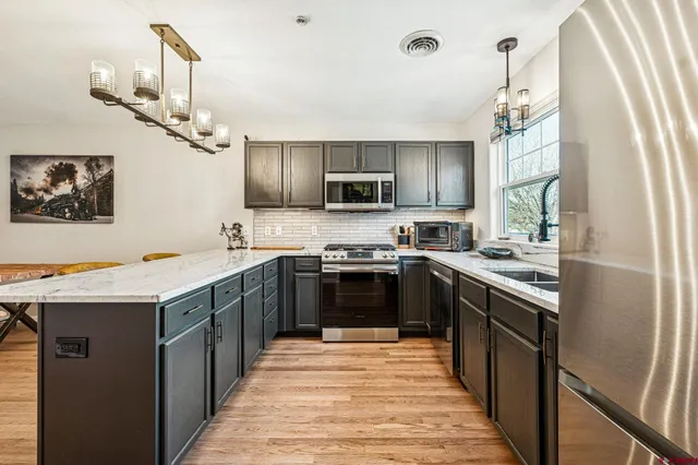 a kitchen with stainless steel appliances granite countertop a stove and a sink
