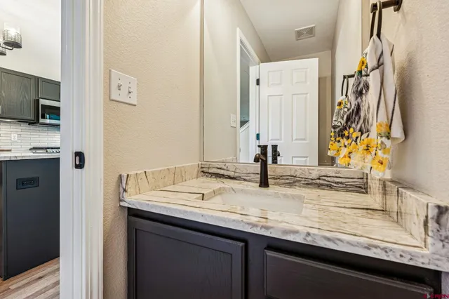a bathroom with a granite countertop sink and a mirror
