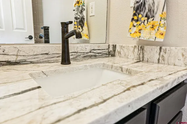 a bathroom with a granite countertop sink and a mirror