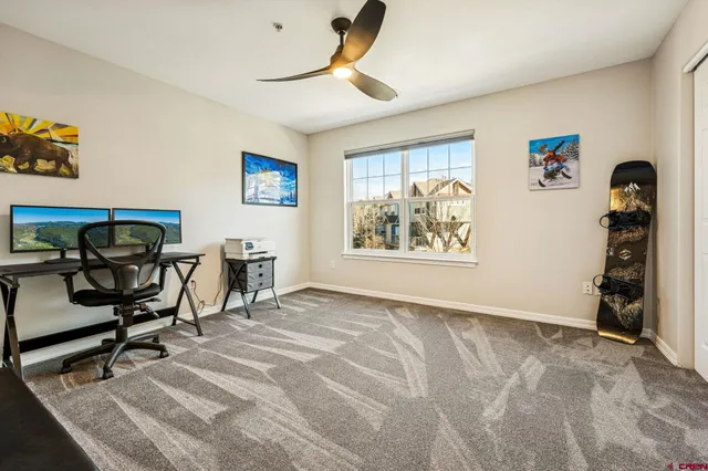 a view of a workspace with furniture and a window