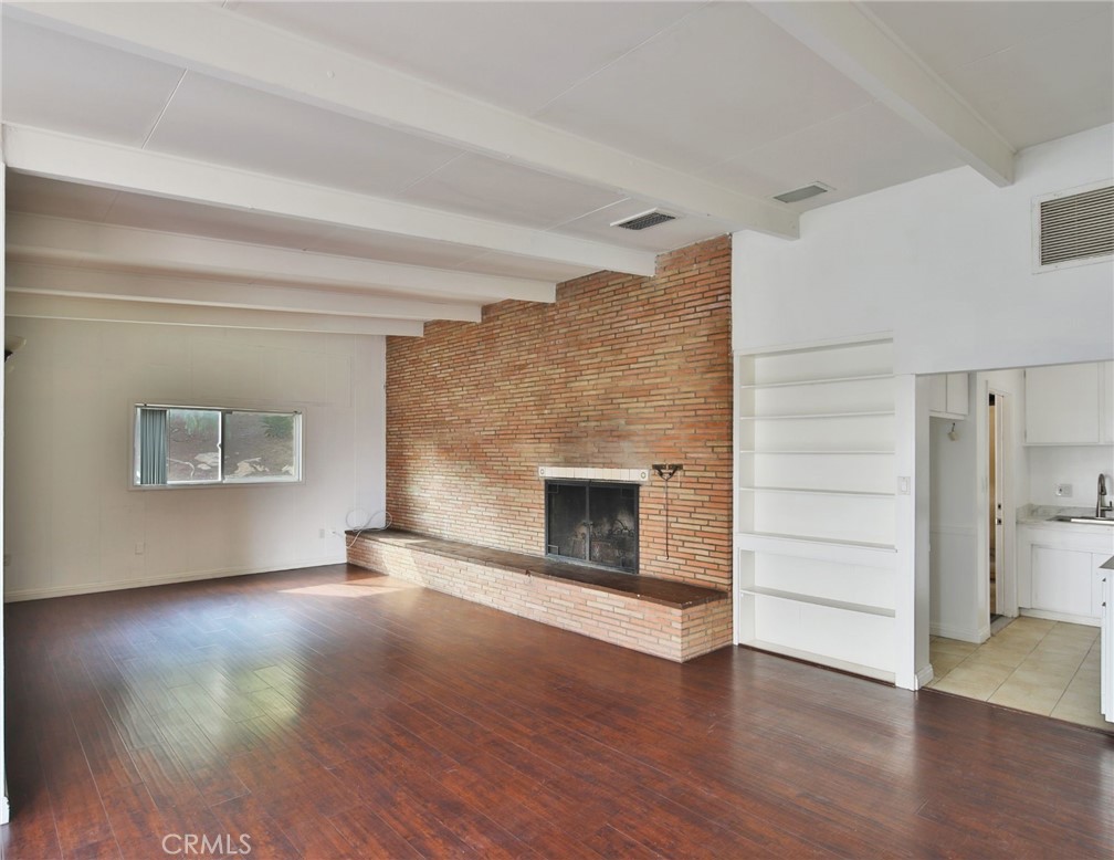 3060 Panorama Road Riverside, CA 92506 - Photo 26 of 38 an empty room with a fireplace and wooden floor