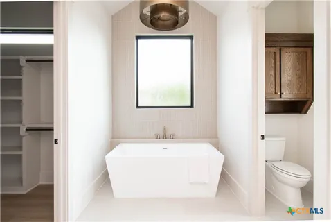 a bathroom with a toilet a sink and mirror