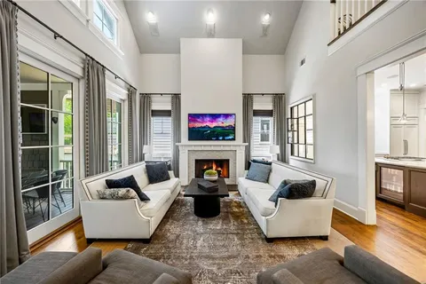a living room with fireplace furniture and floor to ceiling windows