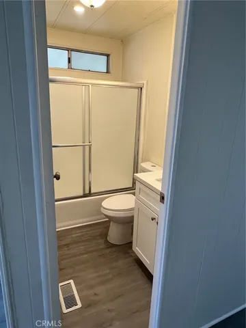 a bathroom with a granite countertop toilet a sink and a mirror