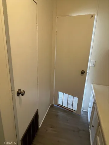 an empty room with wooden floor and entrance