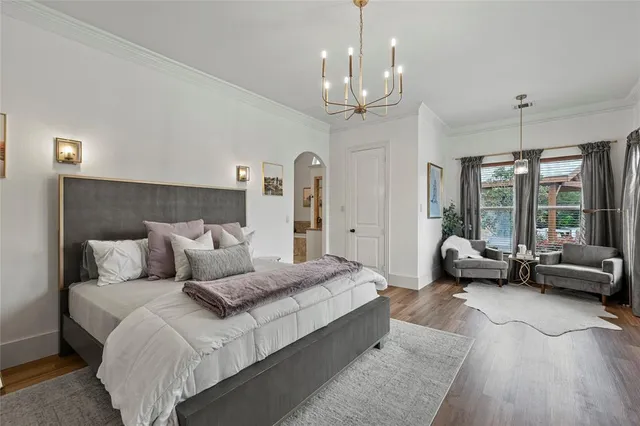 a spacious bedroom with a bed and a chandelier