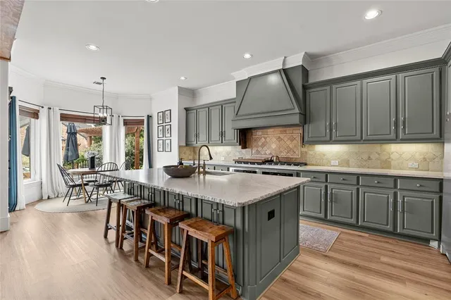 a kitchen with stainless steel appliances granite countertop a kitchen island a stove a table and chairs