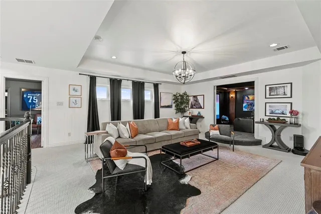 a media room with lots of chairs and chandelier