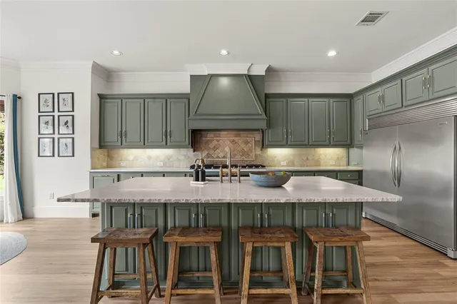 a kitchen with granite countertop a table chairs stove and cabinets
