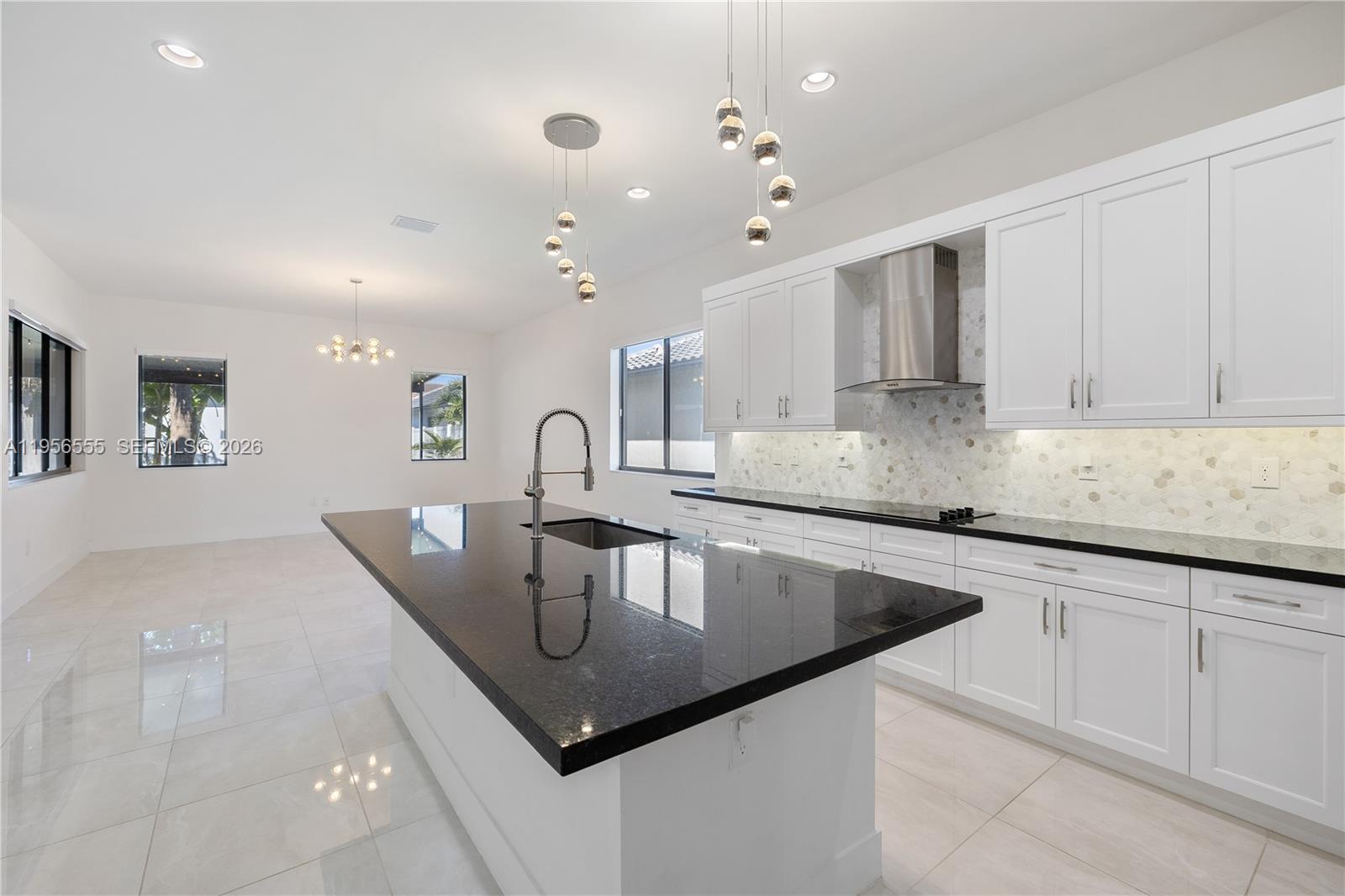 17665 Southwest 46th Street Miramar, FL 33029 - Photo 15 of 41 a kitchen with kitchen island granite countertop a sink and center island