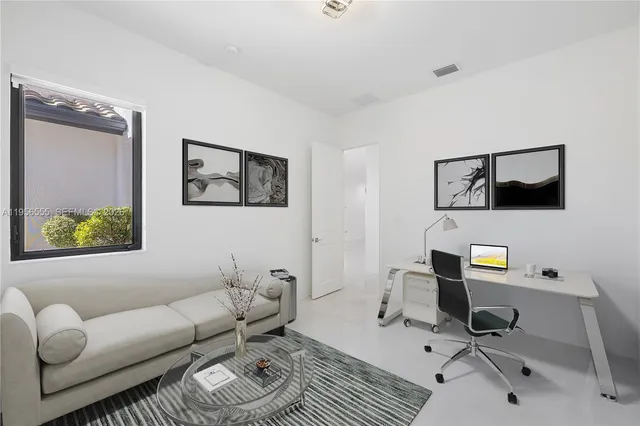 a work room with furniture a rug and a window