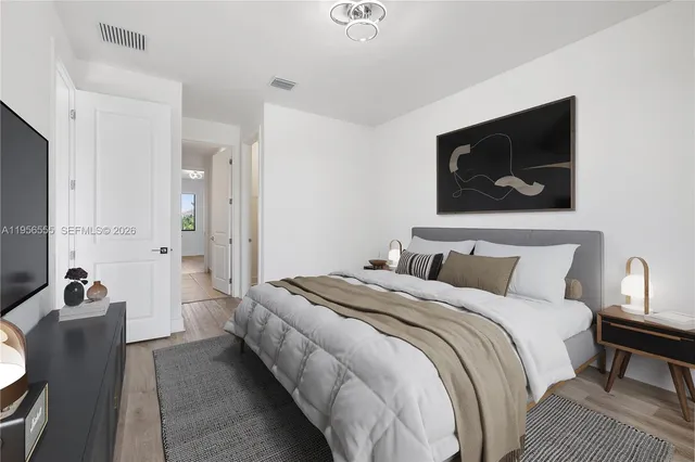 a bedroom with bed and a flat screen tv