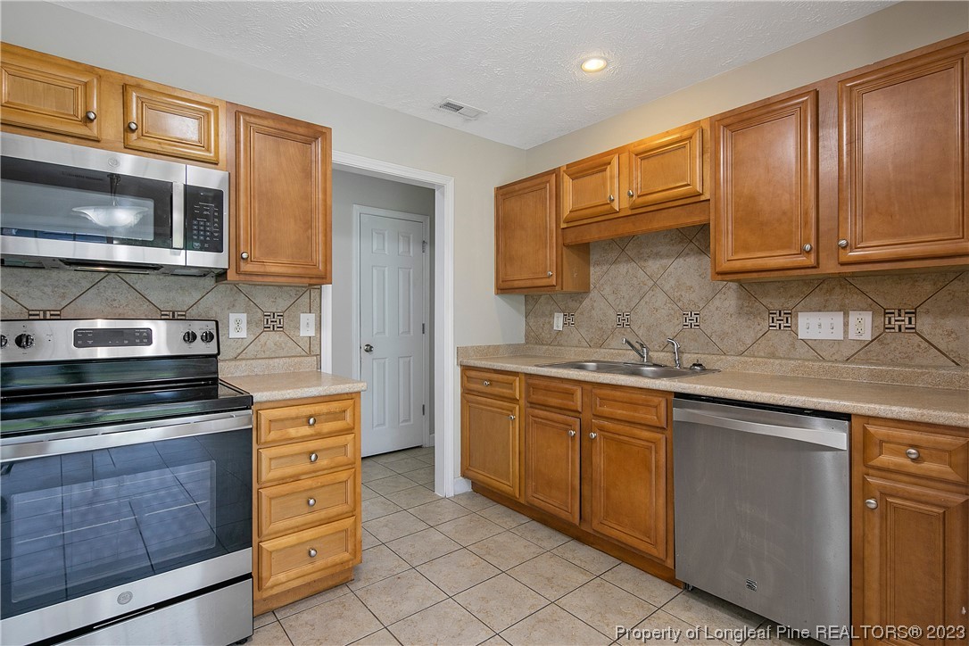 89 Rockingham Street Spring Lake, NC 28390 - Photo 15 of 41 a kitchen with granite countertop cabinets stainless steel appliances and a sink