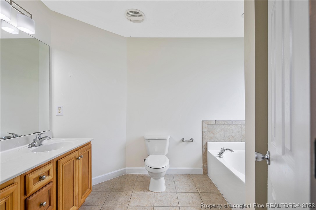 89 Rockingham Street Spring Lake, NC 28390 - Photo 21 of 41 a bathroom with a granite countertop toilet a sink and a bathtub