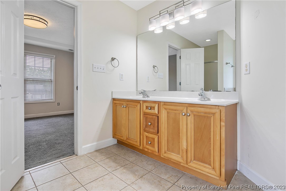 89 Rockingham Street Spring Lake, NC 28390 - Photo 22 of 41 a bathroom with a granite countertop sink a mirror and a shower