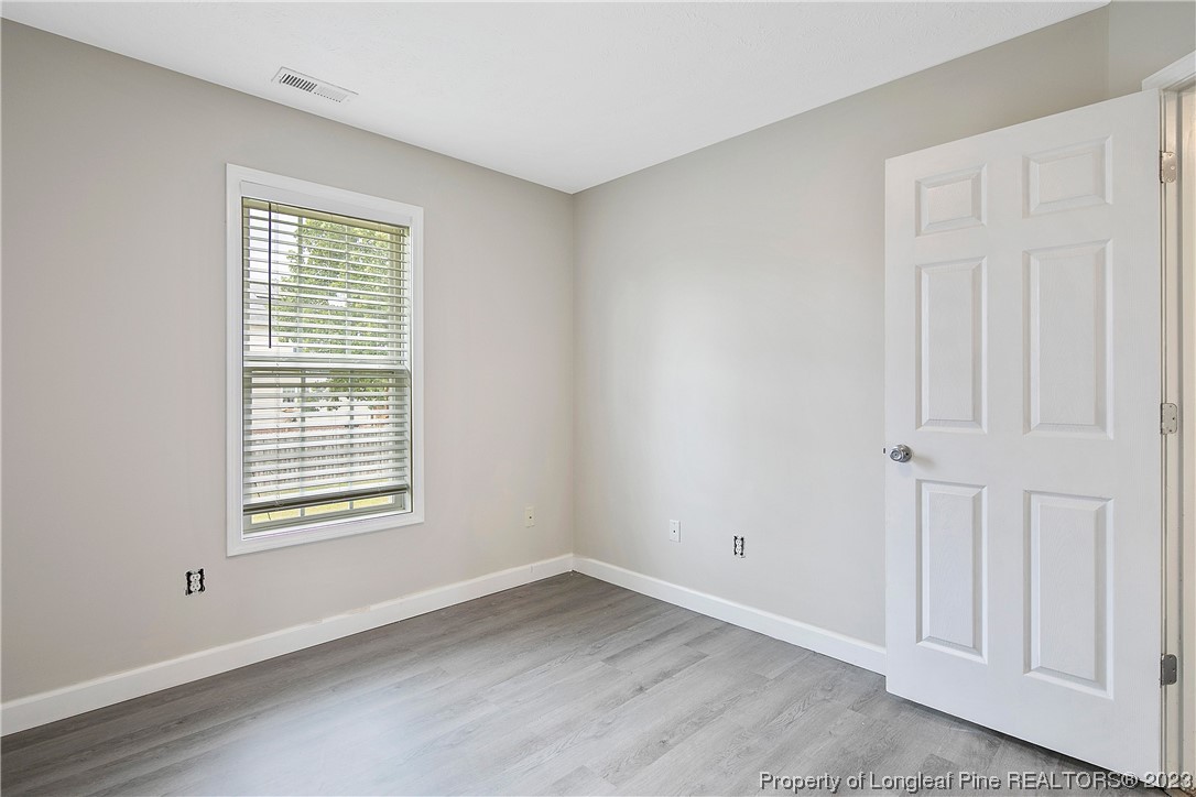 89 Rockingham Street Spring Lake, NC 28390 - Photo 25 of 41 a view of an empty room with wooden floor and a window