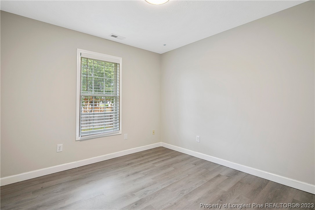89 Rockingham Street Spring Lake, NC 28390 - Photo 30 of 41 a view of an empty room with wooden floor and a window