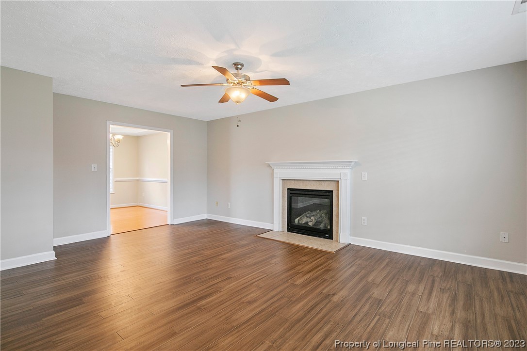 89 Rockingham Street Spring Lake, NC 28390 - Photo 6 of 41 an empty room with wooden floor fireplace and windows