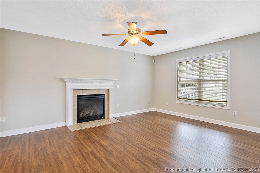 89 Rockingham Street Spring Lake, NC 28390 - Photo 7 of 41 an empty room with wooden floor fireplace and windows