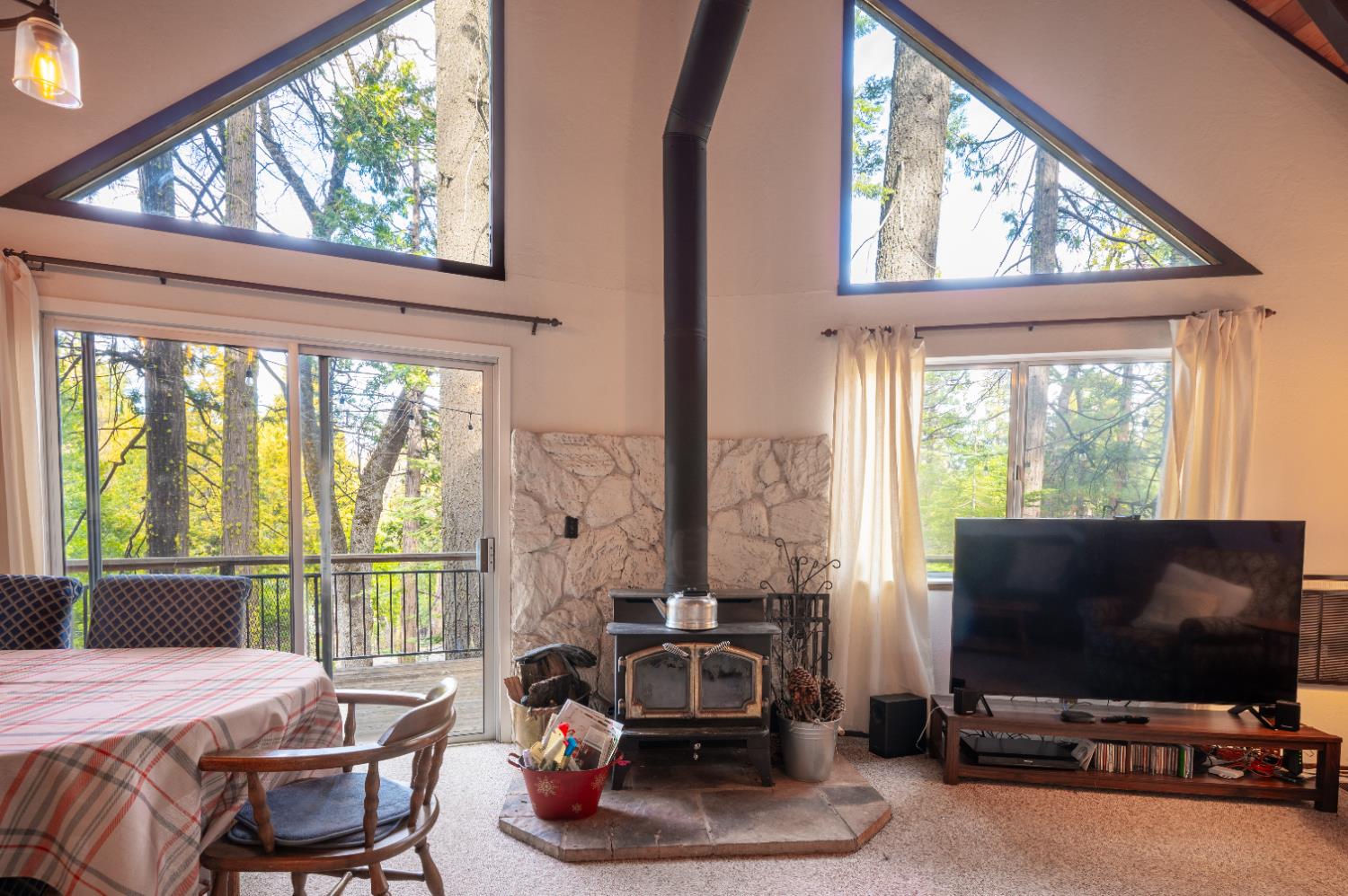 3790 Apache Road Arnold, CA 95223 - Photo 3 of 41 a living room with furniture a flat screen tv and a floor to ceiling window